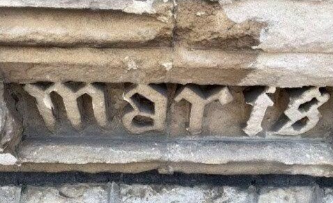 Latin carved beneath front parapet of tower